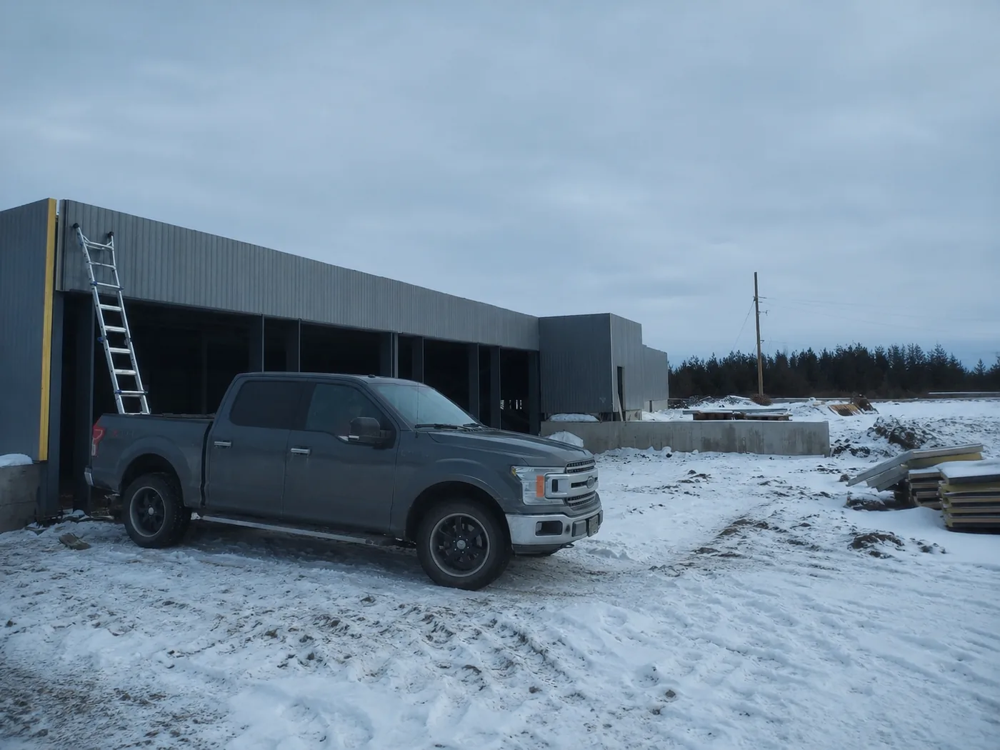 A cold storage facility under construction, with insulated panel erection under way.